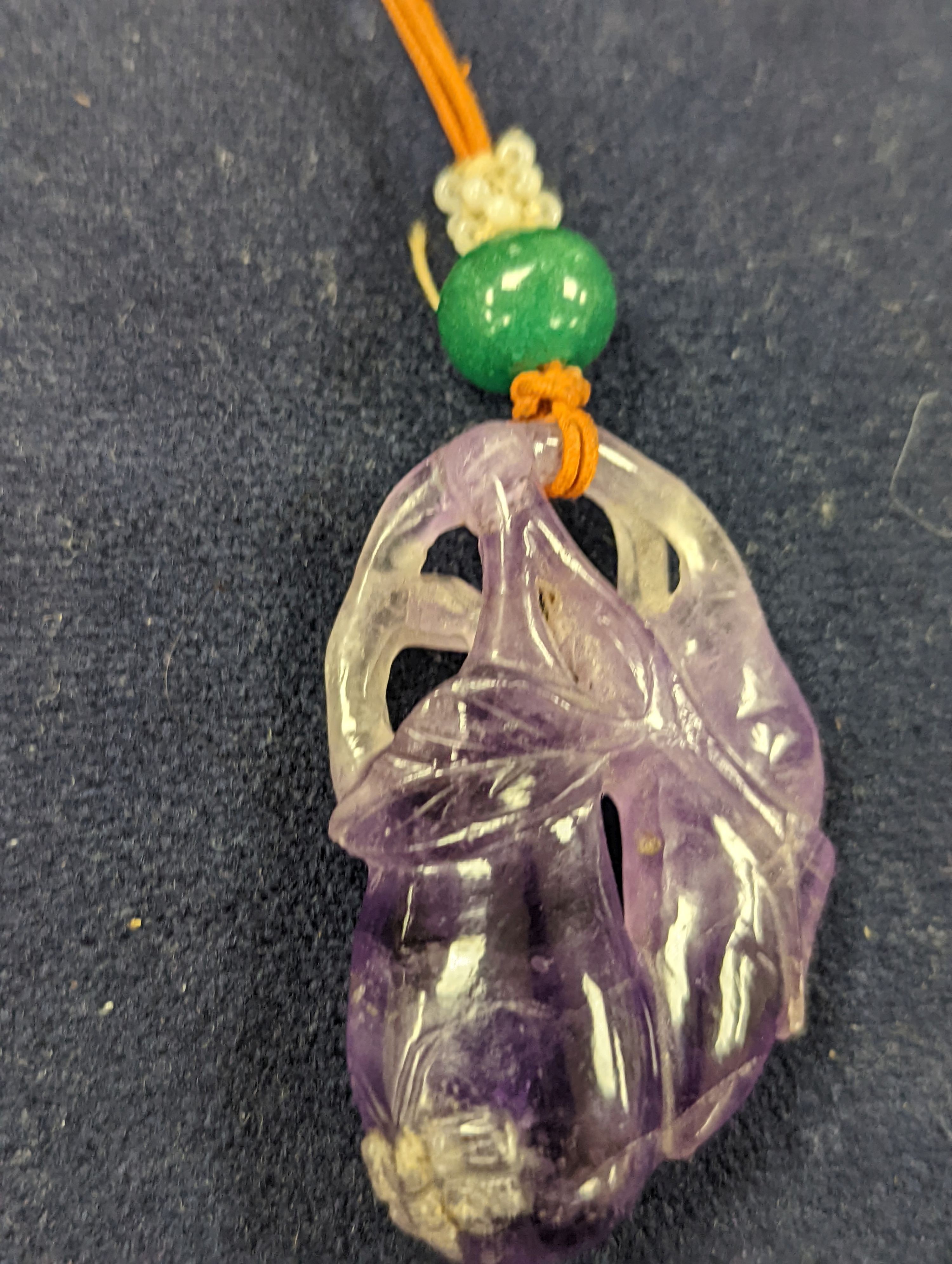 A 19th century Chinese carved amethyst pendant, 5cm on an ornate cord